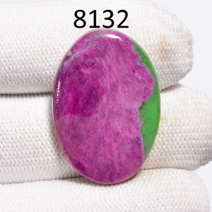 May include: Oval shaped green and pink gemstone cabochon. The stone has a swirling pattern of pink and green.