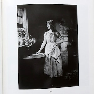 Puede incluir: Libro abierto con dos fotografías en blanco y negro de mujeres con ropa de época. La imagen de la izquierda se titula "The Valentine" y la de la derecha "Who Could Have Seen 27, 1887". El libro está sobre una superficie marrón.