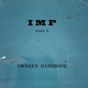 May include: A teal "IMP MARK II OWNER'S HANDBOOK" with white text. The cover features the text "IMP" at the top, followed by "MARK II" and "OWNER'S HANDBOOK". The bottom of the cover reads "A PRODUCT OF THE ROOTES GROUP".
