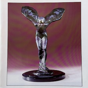 Puede incluir: Folleto de subasta de Christie's con una escultura plateada de una figura alada sobre un fondo burdeos. El folleto incluye el texto "Steam Models and Transport Memorabilia" y detalles de la subasta.