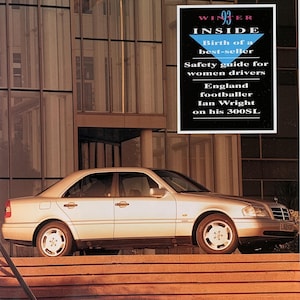 May include: A magazine cover featuring a silver Mercedes sedan parked on steps in front of a modern building. The cover includes the Mercedes logo, the word "MERCEDES", and text that reads "WINTER INSIDE" and "Safety guide for women drivers".