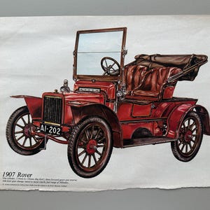 Puede incluir: Ilustración roja de un coche Rover de 1907. El vehículo vintage presenta un interior de cuero marrón, un parabrisas y ruedas de radios. La matrícula dice AI-202. El texto "1907 Rover" es visible en la parte inferior de la imagen.