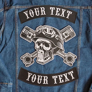May include: Black and white embroidered patch featuring a skull wearing a helmet and goggles with crossed pistons. The patch has the text "YOUR TEXT" above and below the skull.