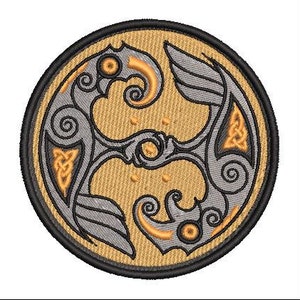 May include: A circular embroidered patch with a gold and gray design. The design features two stylized birds with intricate details and Celtic knotwork.