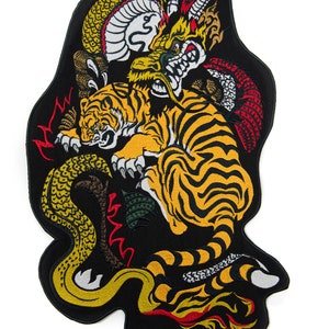 Può includere: Toppa ricamata con un tigre, un drago e un serpente in una posa dinamica. La tigre è gialla e nera, il drago è rosso e giallo, e il serpente è verde e giallo. La toppa è su uno sfondo nero.