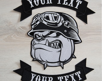 May include: Black and white embroidered patch of a bulldog wearing a helmet and goggles with the text "YOUR TEXT" on two black banners.