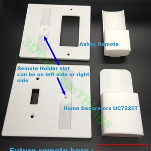 May include: White plastic wall plate with a slot for a light switch and a remote control holder. The text "Ashby Remote" and "Home Decorators UC7225T" are visible on the plate. The text "Remote Holder slot can be on left side or right side" is also visible. The text "Future remote here" is visible below the plate.