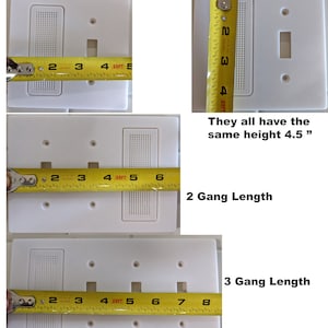 May include: Three white electrical outlet covers with different numbers of openings. The covers are measured with a yellow tape measure. The covers are 4.5 inches tall. The first cover has one opening, the second cover has two openings, and the third cover has three openings.