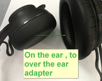 Könnte beinhalten: Zwei schwarze Kopfhörer-Ohrpolster, eines ist ein On-Ear-Ohrpolster und das andere ein Over-Ear-Ohrpolster.  "On the ear, to over the ear adapter" steht auf einem gelben Haftnotiz.
