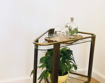 A rare Art Deco 1920s golden bar cart made of brass with two tiers of glass on rubber wheels.