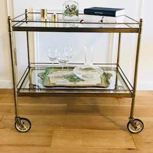 Exklusiver, XXL-neoklassizistischer Barwagen / Servierwagen aus Messing mit zwei Glasplatten auf Gummirädern aus den 50er Jahren.