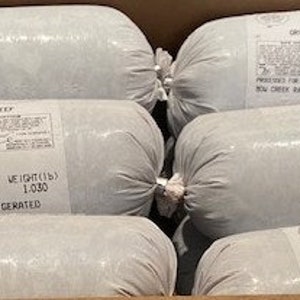 May include: A cardboard box filled with six cylindrical packages of ground beef. Each package is wrapped in white plastic and labeled with text including the weight, 1.030 lbs, and the words "KEEP REFRIGERATED".