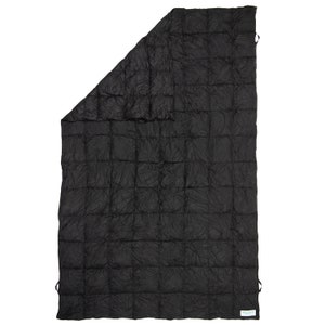 May include: A black quilted blanket with a white tag that says "Made in USA".