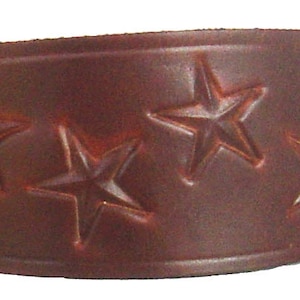 May include: A brown leather cuff bracelet with five embossed star designs.