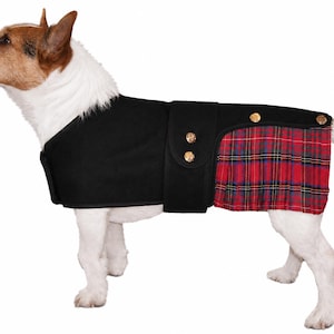 May include: A black dog coat featuring a solid black upper section and a red, green, and blue plaid pleated skirt section. The garment includes a wide black strap across the midsection secured with two gold-toned buttons and two additional gold-toned buttons on the rear flap.