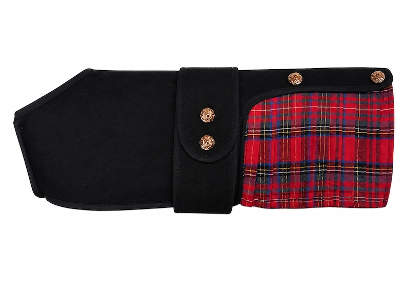 May include: A black pet coat featuring a solid black main body with a central vertical strap secured by two gold-toned metal buttons. The right side displays a pleated red, blue, and yellow plaid fabric panel accented with two additional gold-toned buttons.