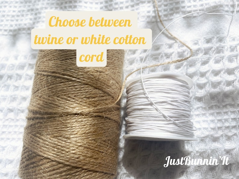 Op de afbeelding: Twee spoelen touw, een bruin en een wit. De bruine spoel is ge&euml;tiketteerd "twine" en de witte spoel is ge&euml;tiketteerd "white cotton cord". De tekst "Choose between twine or white cotton cord" staat boven de spoelen.