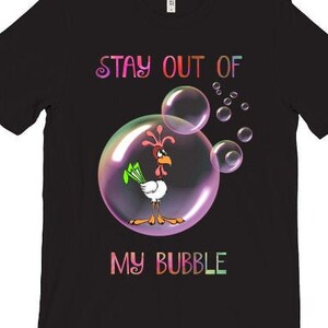May include: Black t-shirt with a colorful graphic of a rooster inside a bubble. The text "Stay out of my bubble" is printed below the bubble.