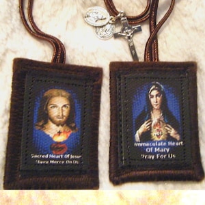 May include: Two brown fabric prayer cards with images of Jesus and Mary. The card on the left features a portrait of Jesus with the text "Sacred Heart of Jesus Have Mercy On Us". The card on the right features a portrait of Mary with the text "Immaculate Heart of Mary Pray For Us".