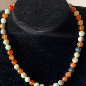 Puede incluir: Un collar de cuentas multicolores con cuentas de cornalina, aventurina y amazonita. El collar tiene un cierre de oro.