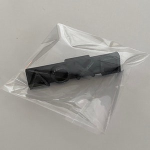 May include: A black plastic pin with the word "SONY" printed on it. The pin is packaged in a clear plastic bag.