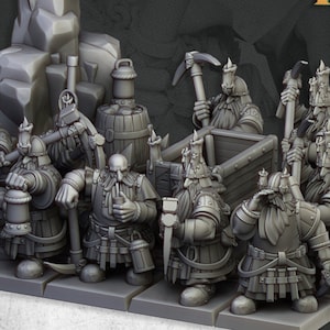 May include: A group of gray miniature figurines of dwarves, some holding pickaxes and lanterns. The figurines are arranged on a gray platform, with the text "AUGUST RELEASE" and "SONS OF YMIR" visible.
