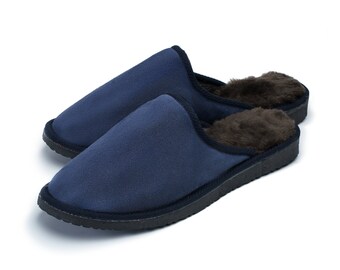 May include: A pair of blue suede slippers with a brown faux fur lining. The slippers have a closed toe and a slip-on design.