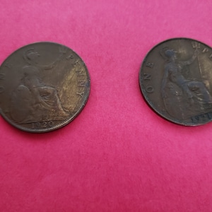 May include: Two copper British pennies, one from 1920 and the other from 1921. Both coins feature the profile of a woman with a crown on her head.