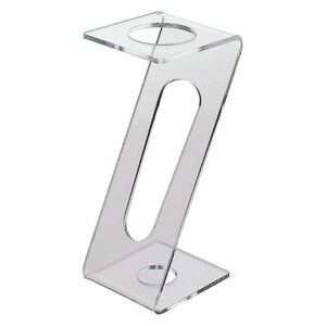 May include: Clear acrylic display stand with two circular openings. The stand is shaped like a Z and has a rectangular base.