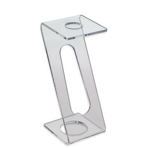 May include: Clear acrylic stand with two circular openings for displaying items. The stand has a Z-shaped design and a square base.