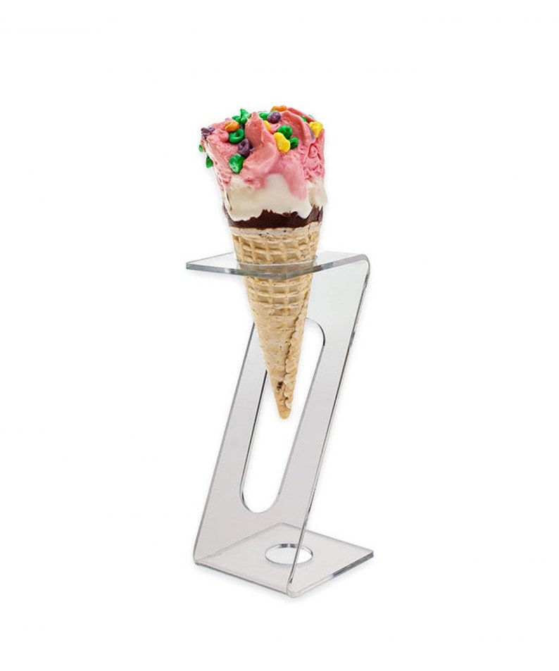 May include: A clear acrylic ice cream cone holder with a single ice cream cone with pink and white ice cream and colorful sprinkles.