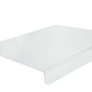 May include: A clear, rectangular cutting board with a slightly raised edge on one side. The board is made of a transparent material, likely plastic or glass, and is designed for food preparation. The overall design is simple and functional.