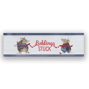 Könnte beinhalten: Ein weißes Stoffband mit blauen Streifen und zwei Mäuse, die eine rote Schnur mit roten Perlen halten. Der Text "Lieblings Stück" ist in Rot auf dem Band aufgedruckt.