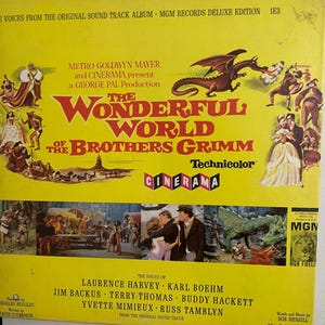 May include: A yellow record album cover with a dragon and a scene from the movie "The Wonderful World of the Brothers Grimm". The album cover features the title of the movie, the names of the actors, and the words "Technicolor" and "Cinerama".