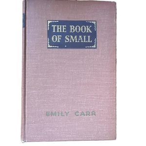 May include: A vintage book titled "THE BOOK OF SMALL" by Emily Carr. The book has a textured, dusty rose cover with a dark blue rectangular label. The title and author's name are printed in a light color.