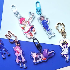 Puede incluir: Seis llaveros de personajes de anime coloridos con diferentes diseños. Cada llavero presenta un personaje diferente con ropa y accesorios únicos. Los llaveros están hechos de acrílico transparente y tienen un anillo de metal para sujetarlos a llaves o bolsos.