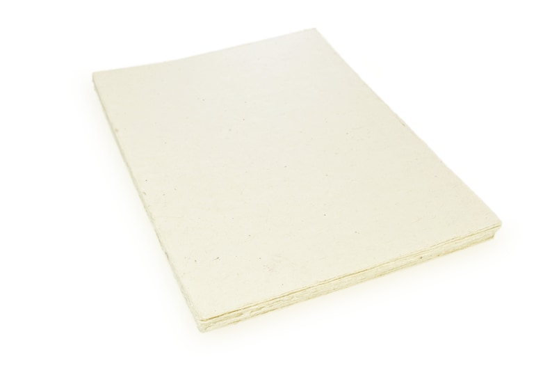 Puede incluir: Una pila de hojas de papel en blanco, de color blanquecino, con una textura ligeramente rugosa.
