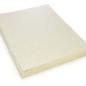 Puede incluir: Una pila de hojas de papel de color blanquecino, probablemente hechas a mano, con una textura rugosa. El papel es ligeramente transl&uacute;cido y tiene un aspecto natural y r&uacute;stico.