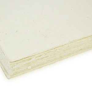 Puede incluir: Primer plano de una pila de hojas de papel de color blanquecino. El papel tiene una textura ligeramente rugosa y est&aacute; hecho de materiales reciclados.