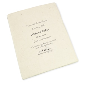 May include: A pack of 100 sheets of natural Lokta paper, 8.5 x 11 inches, handmade with a deckle edge. The paper is calendered for use with laser and inkjet printers. The packaging features a logo for Kathmandu Valley Co.