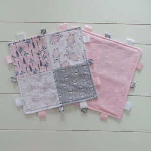 May include: Two baby blankets, one pink and one multi-colored. The multi-colored blanket is made of four squares of different fabrics with a woodland, bunny, moon and stars, and deer print. Both blankets have satin ribbon ties.