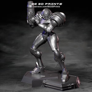 Op de afbeelding: Een zilverkleurig beeldje van een personage in een futuristisch harnas, met een groot wapen. De figuur staat dynamisch op een rechthoekige basis. De tekst "BG 3D PRINTS" en een websiteadres zijn zichtbaar bovenaan.