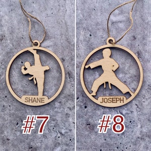 May include: Two wooden ornaments shaped like circles with a karate figure silhouette inside. The ornaments have a string for hanging and the names "Shane" and "Joseph" are written on the bottom. The ornaments are numbered "#7" and "#8".