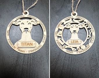 May include: Two wooden dog ornaments with a natural finish. Each ornament features a dog silhouette within a circular frame, with the dog's name on a small plaque. One says "TITAN" and the other says "LEIA". The words "LOVABLE, FRIENDLY, COMPANION, JOYOUS, DEPENDABLE, WARM, ADORABLE, LOYAL, CARING" are engraved around the frame.