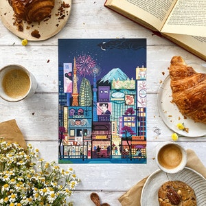 May include: A vibrant print of a Japanese cityscape at night, featuring iconic landmarks, fireworks, and Mount Fuji. The image is complemented by pastries, coffee, a book, flowers, and wooden spoons, creating a warm, inviting atmosphere.