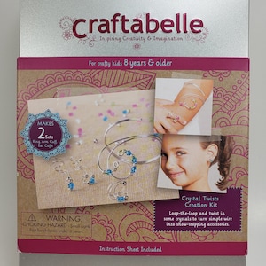 May include: A silver tin with a pink and brown patterned background. The tin contains a jewellery making kit with instructions. The kit includes silver wire, crystals, and instructions for making rings, bracelets, and earrings. The text on the tin reads "Craftabelle Inspiring Creativity & Imagination" and "For crafty kids 8 years & older". The text on the tin also reads "Crystal Twists Creation Kit" and "Loop-the-loop and twist in some crystals to turn simple wire into show-stopping accessories."