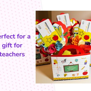 May include: A gift basket decorated with school-themed cutouts, including pencils, apples, and a school bus. The basket contains Amazon gift cards and has the text "Best Teacher Ever!" on the front.