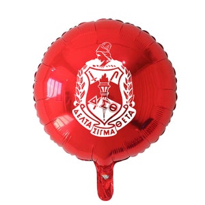 May include: Red foil balloon with a white crest featuring a torch, a shield, and the text "Delta Sigma Theta".