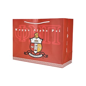 May include: Red and white shopping bag with a Kappa Alpha Psi fraternity crest and the words "Kappa Alpha Psi" printed on the front.