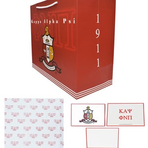May include: Red gift bag with a white handle and Kappa Alpha Psi logo. The bag has a white stripe at the bottom and the number 1911 printed on the side. The bag comes with a white card with the Kappa Alpha Psi crest and a white card with the text "KAU ΦΝΠ".